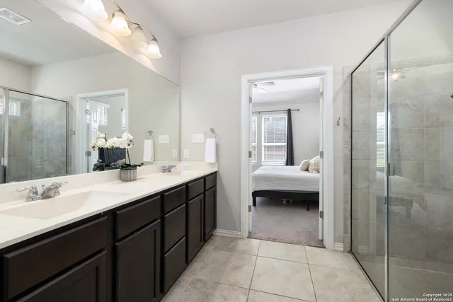 a en suite bathroom with a shower sink and a mirror