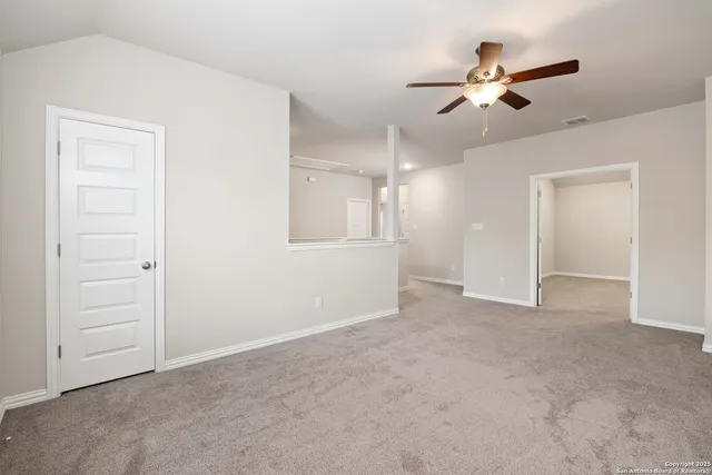an empty room with closet and fan
