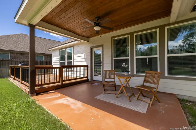 a view of a patio with table and chairs with wooden floor and fence