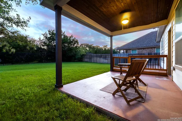 a view of a backyard with table and chairs potted plants and a palm tree