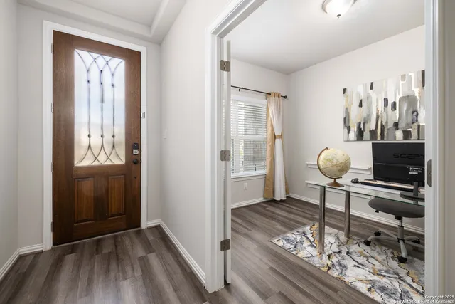 a view of a workspace wooden floor and windows in a room