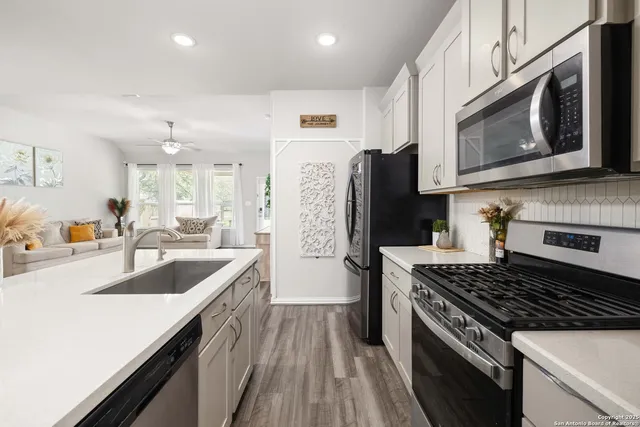 a kitchen with granite countertop a sink stove and refrigerator