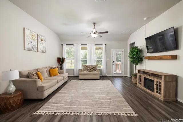 a living room with furniture a flat screen tv and a fireplace