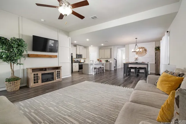 a living room with furniture kitchen view and a fireplace