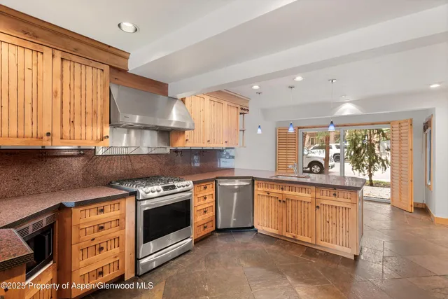 a kitchen with stainless steel appliances granite countertop a stove and a sink