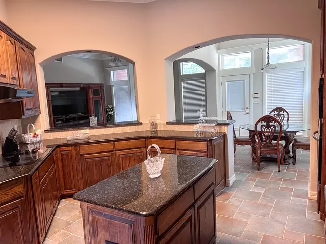 a kitchen with stainless steel appliances granite countertop a stove a sink and a refrigerator