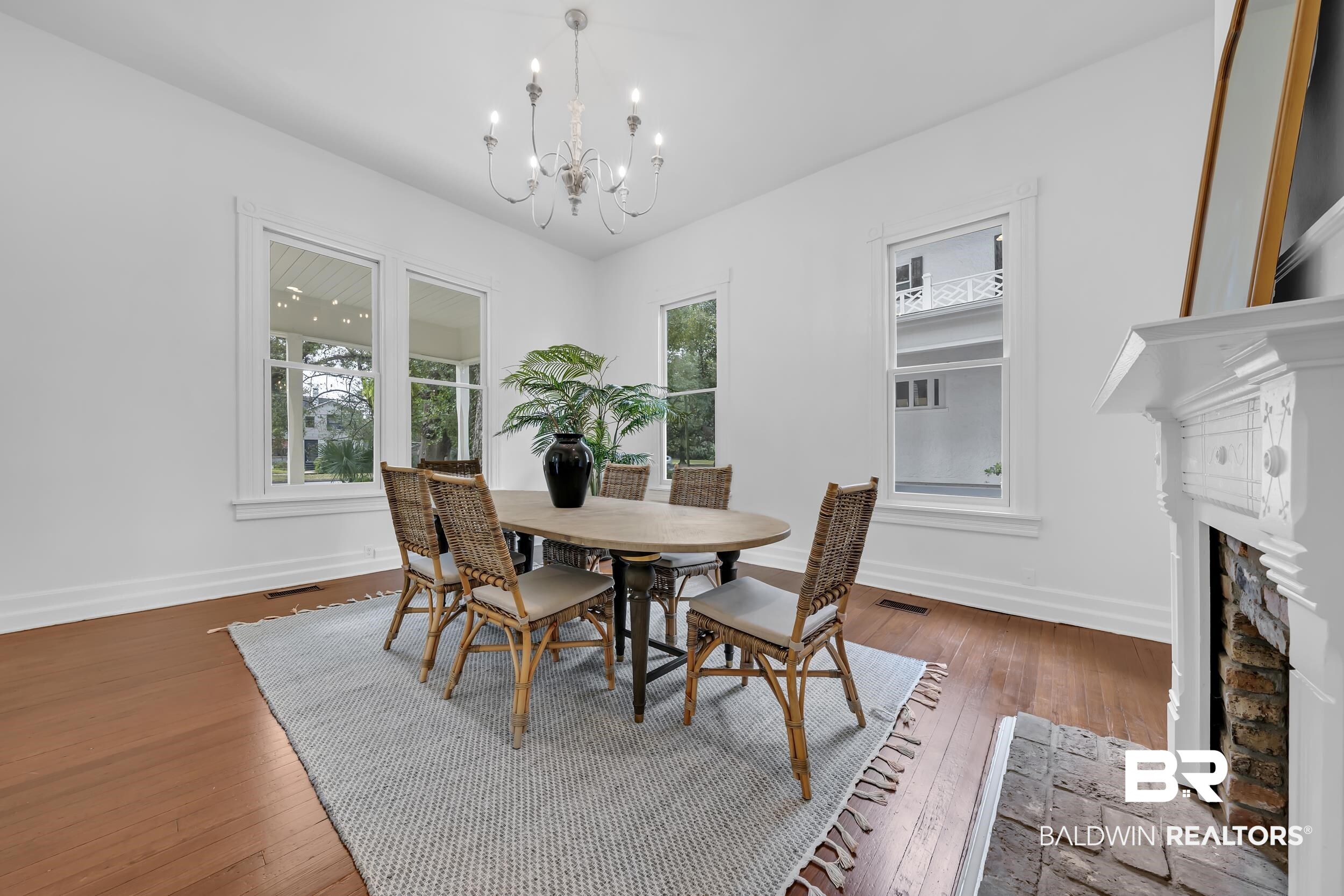 1662 Government Street Mobile, AL 36604 - Photo 15 of 33 Dining space featuring hardwood / wood-style floors, healthy amount of natural light, a fireplace, and a chandelier