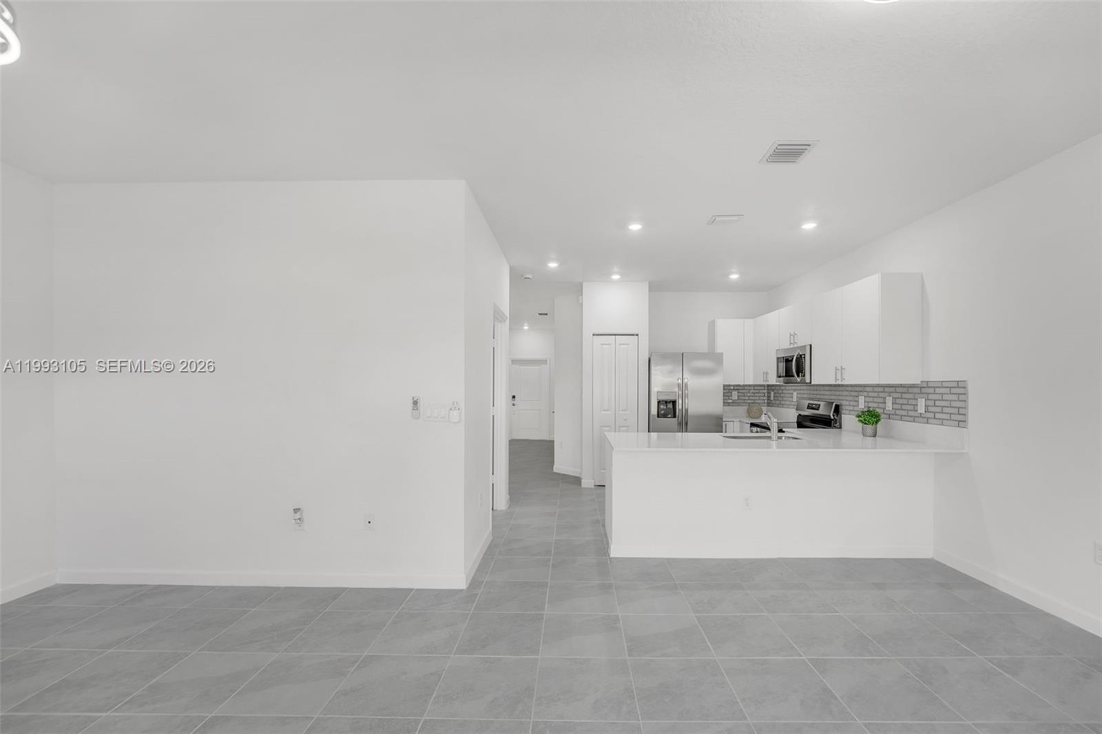 2425 Southeast 28th Drive, Unit 2425 Homestead, FL 33035 - Photo 19 of 98 a view of kitchen with kitchen island white cabinetry and refrigerator