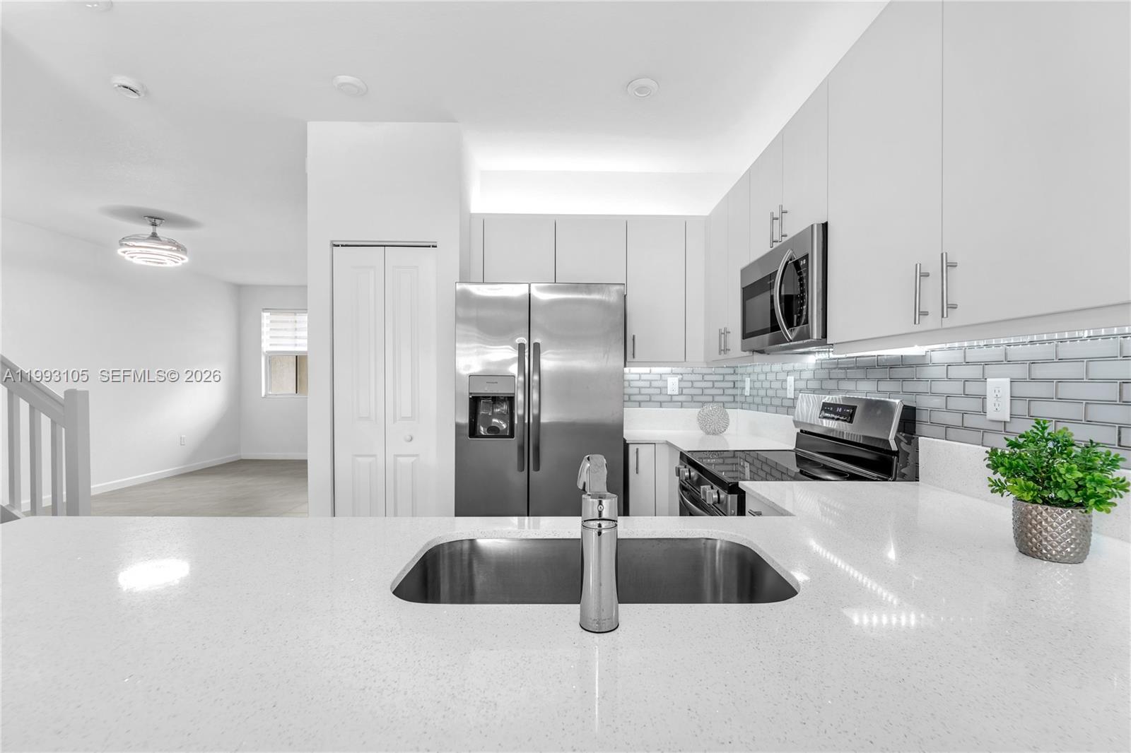 2425 Southeast 28th Drive, Unit 2425 Homestead, FL 33035 - Photo 22 of 98 a kitchen with stainless steel appliances a sink a microwave a stove and refrigerator