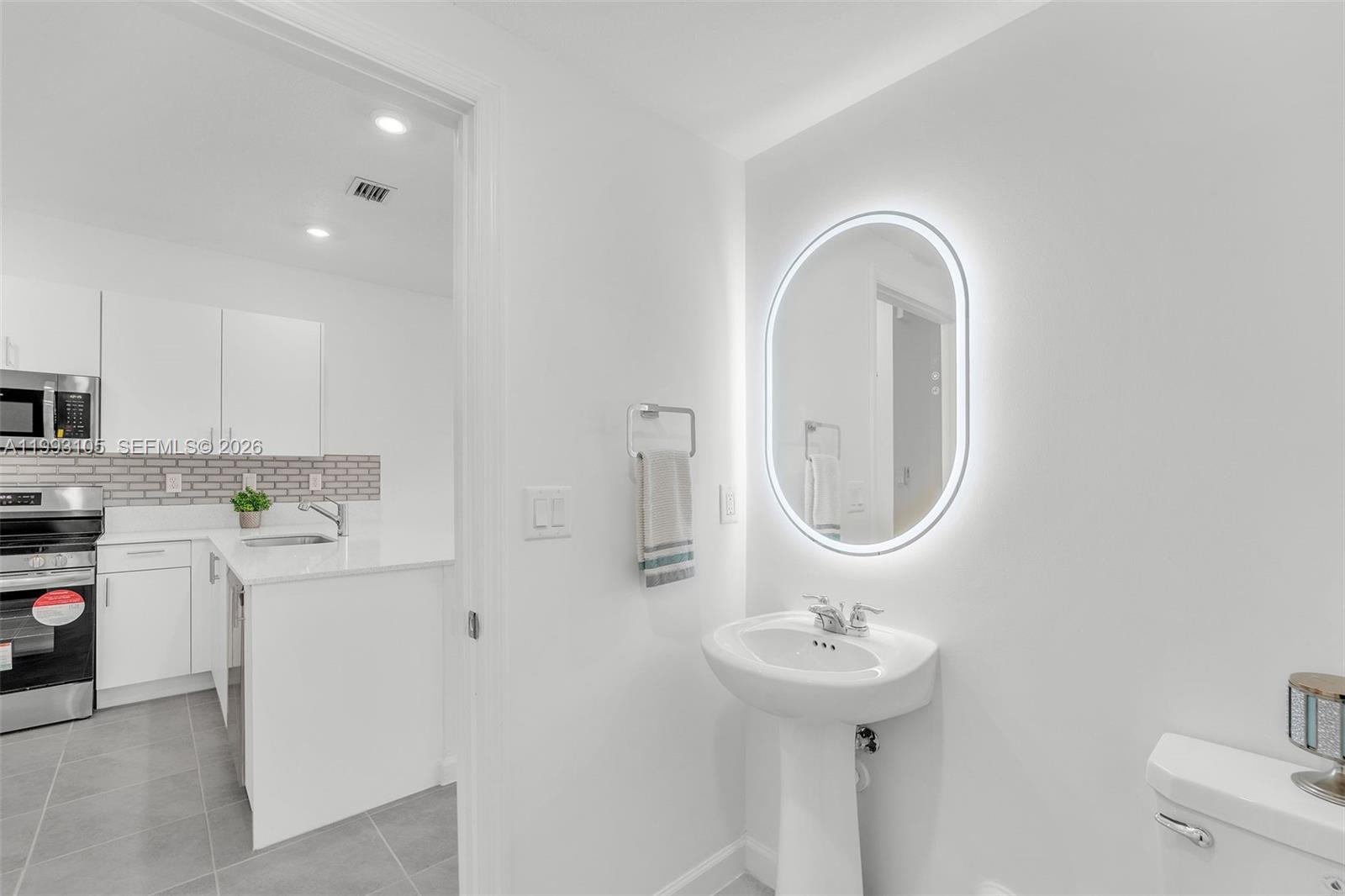 2425 Southeast 28th Drive, Unit 2425 Homestead, FL 33035 - Photo 5 of 98 a bathroom with a sink a toilet and a mirror