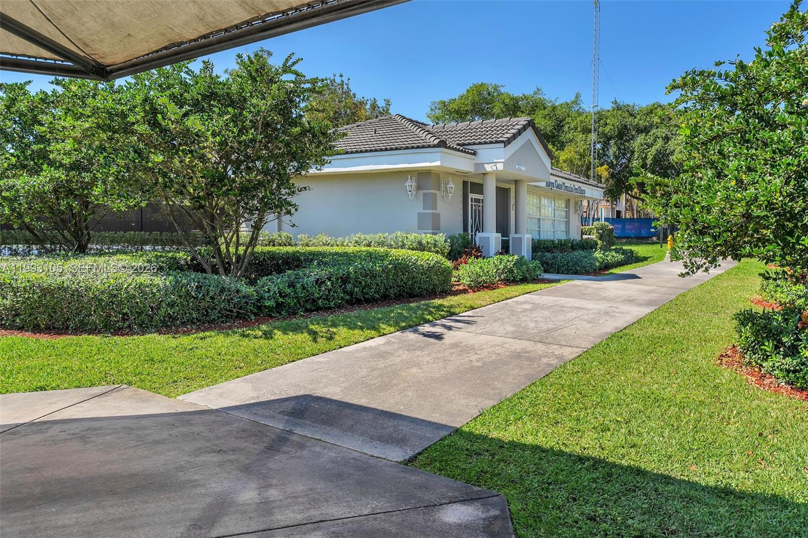 2425 Southeast 28th Drive, Unit 2425 Homestead, FL 33035 - Photo 87 of 98 a front view of a house with a yard and potted plants