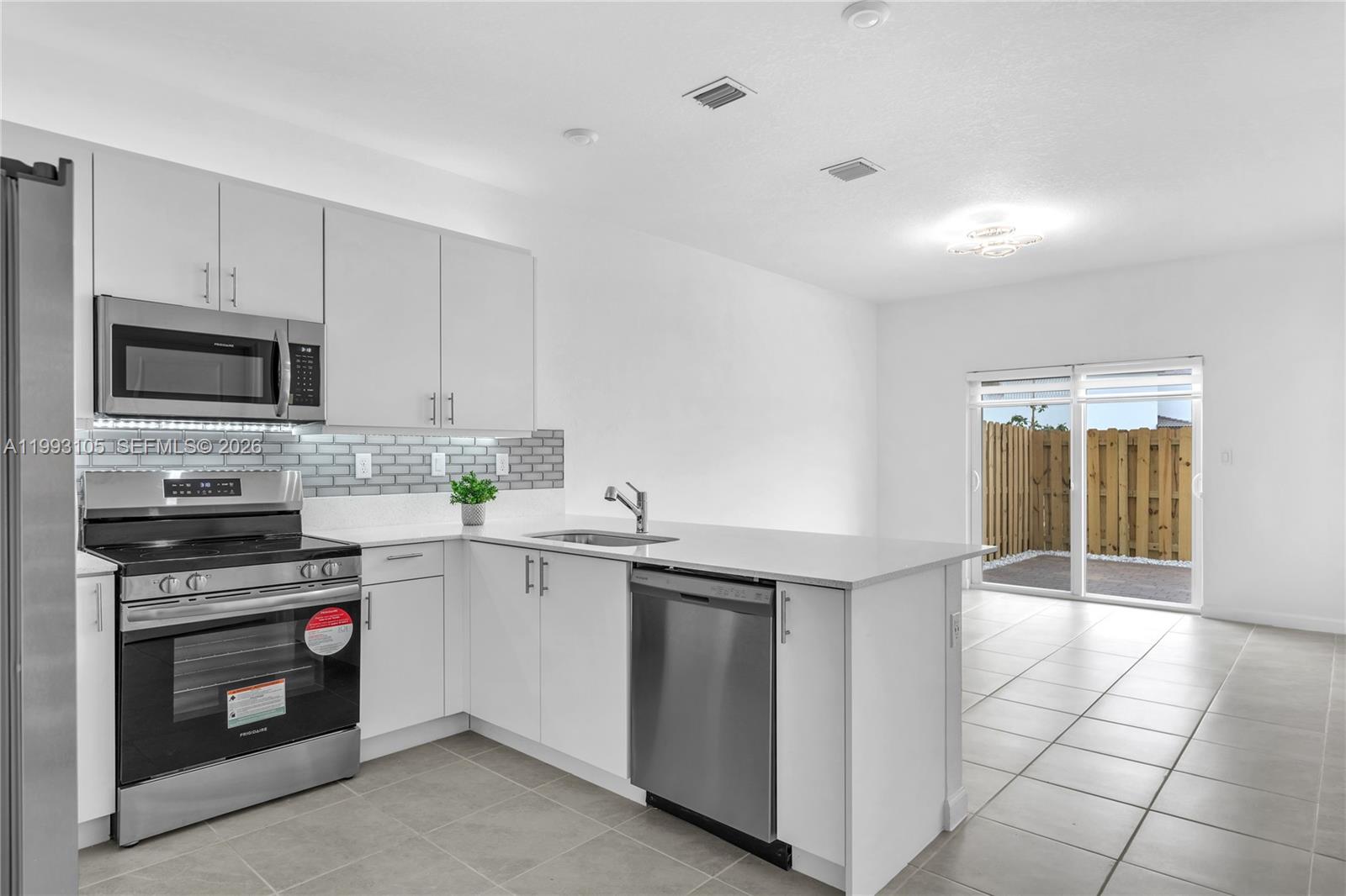 2425 Southeast 28th Drive, Unit 2425 Homestead, FL 33035 - Photo 91 of 98 a kitchen with stainless steel appliances a stove sink and microwave
