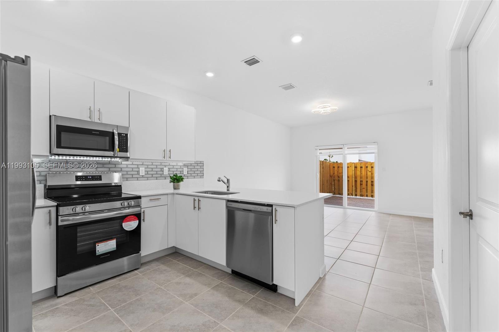 2425 Southeast 28th Drive, Unit 2425 Homestead, FL 33035 - Photo 96 of 98 a kitchen with stainless steel appliances a stove sink and microwave