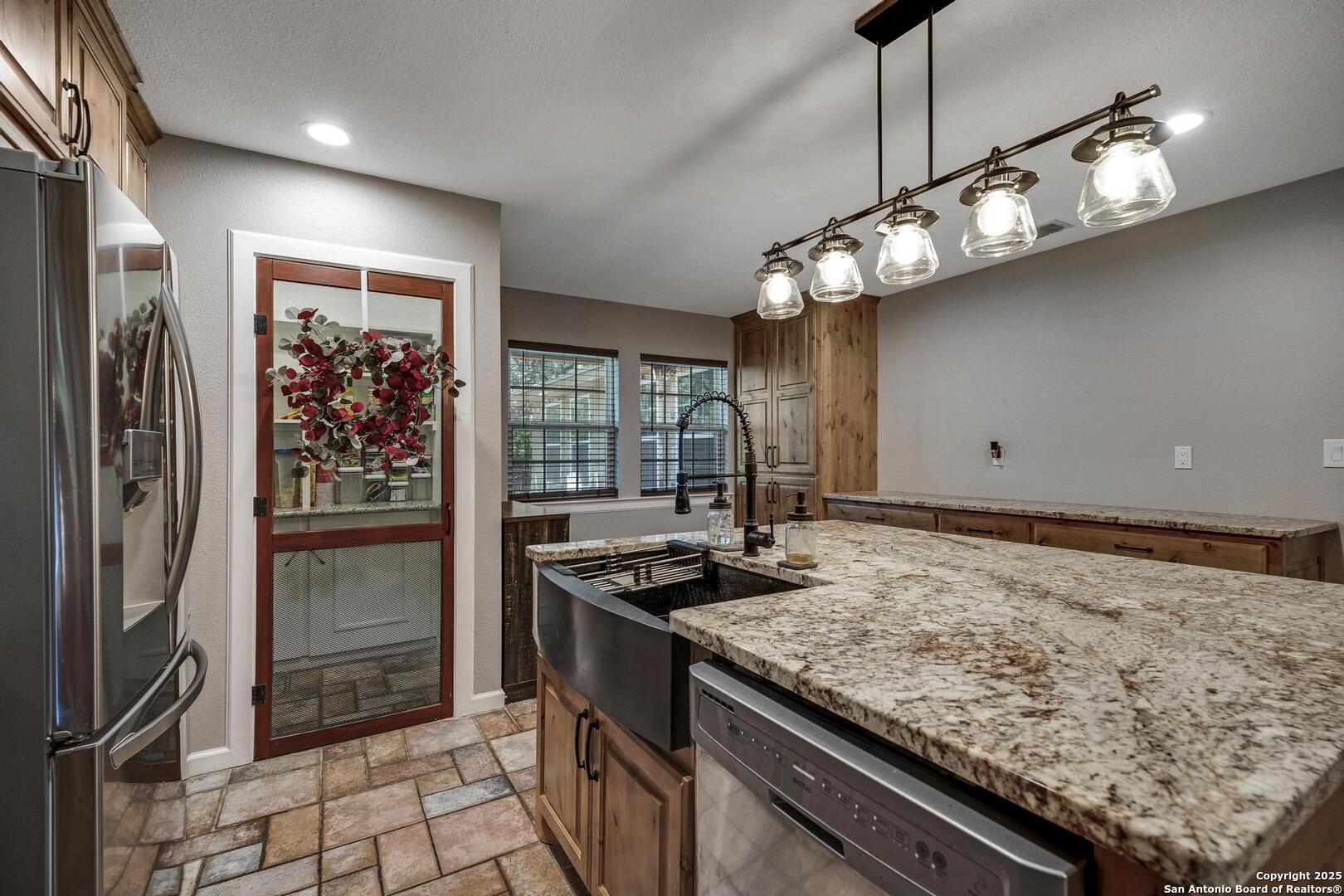 10855 Jericho Road Helotes, TX 78023 - Photo 14 of 59 a kitchen with stainless steel appliances granite countertop cabinets and wooden floor