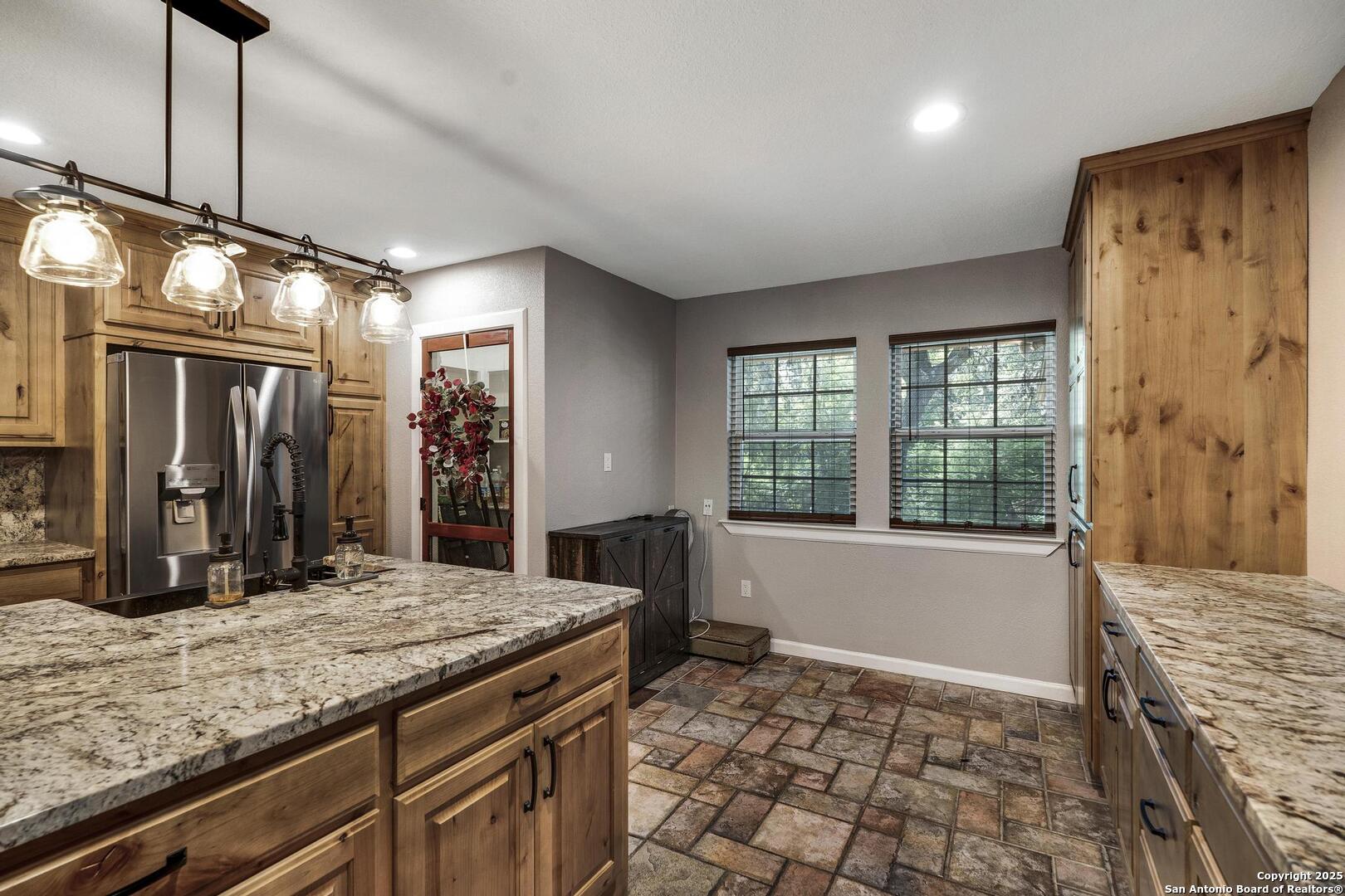 10855 Jericho Road Helotes, TX 78023 - Photo 18 of 59 a bathroom with a granite countertop sink a large mirror and a bathtub