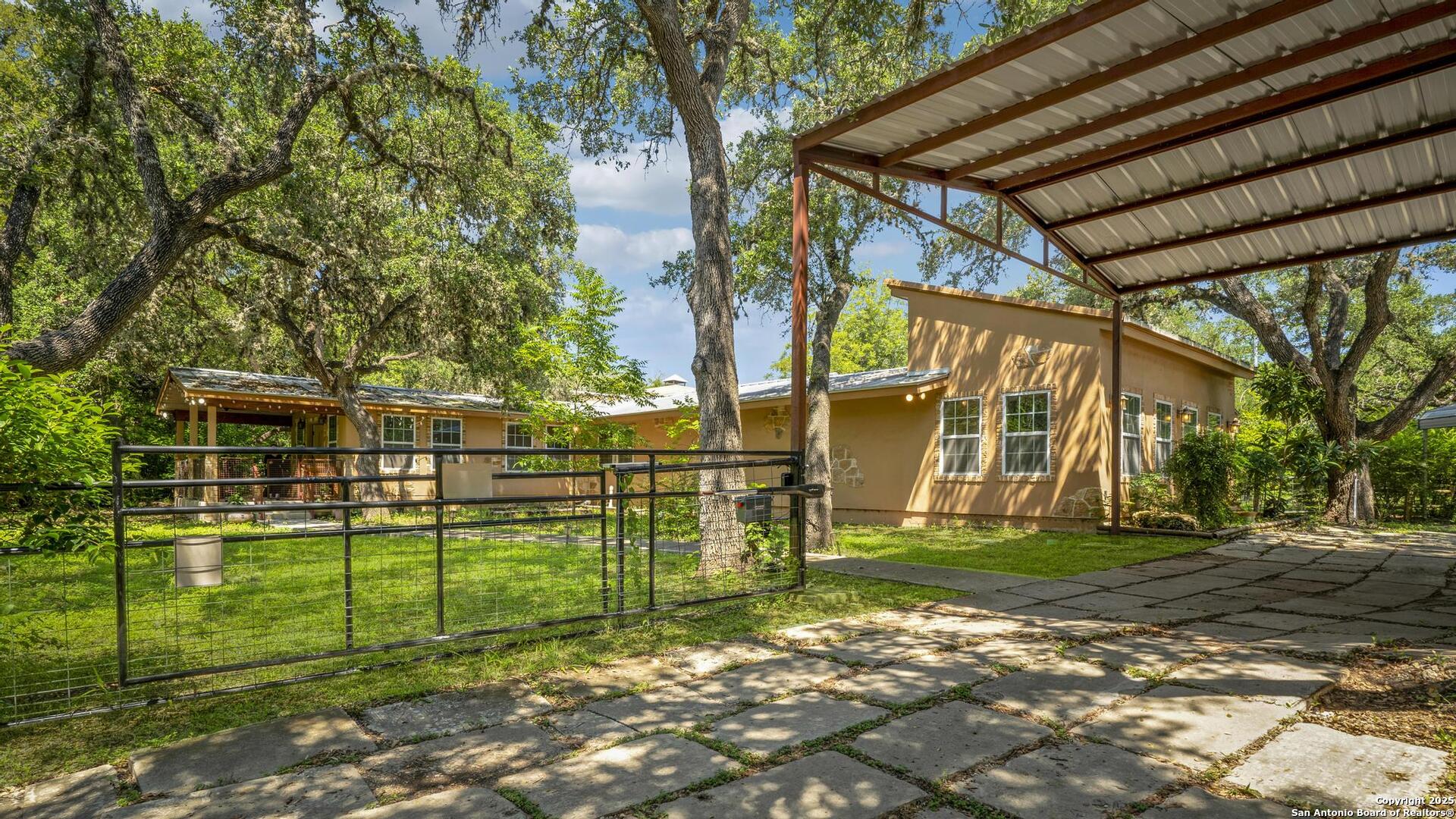 10855 Jericho Road Helotes, TX 78023 - Photo 3 of 59 a view of a backyard with table and chairs and potted plants