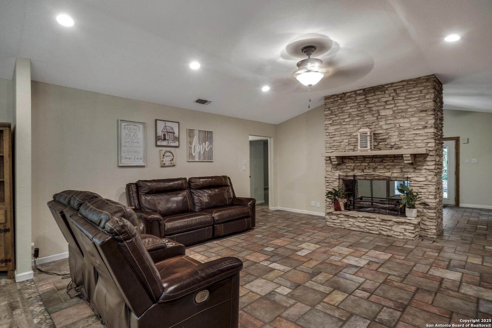10855 Jericho Road Helotes, TX 78023 - Photo 8 of 59 a living room with furniture a fireplace and a dining table with wooden floor