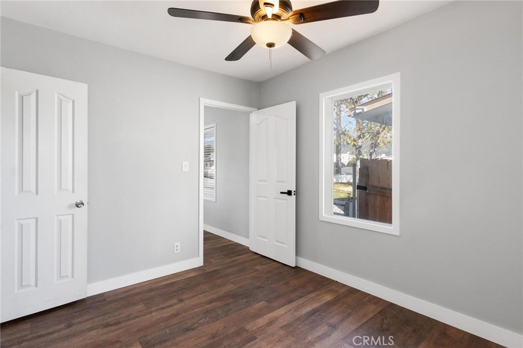 34789 Wildwood Canyon Road Yucaipa, CA 92399 - Photo 12 of 52 an empty room with wooden floor fan and windows