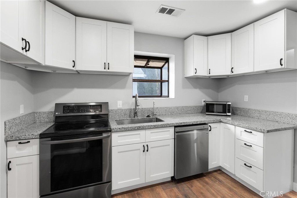 34789 Wildwood Canyon Road Yucaipa, CA 92399 - Photo 17 of 52 a kitchen with white cabinets and appliances