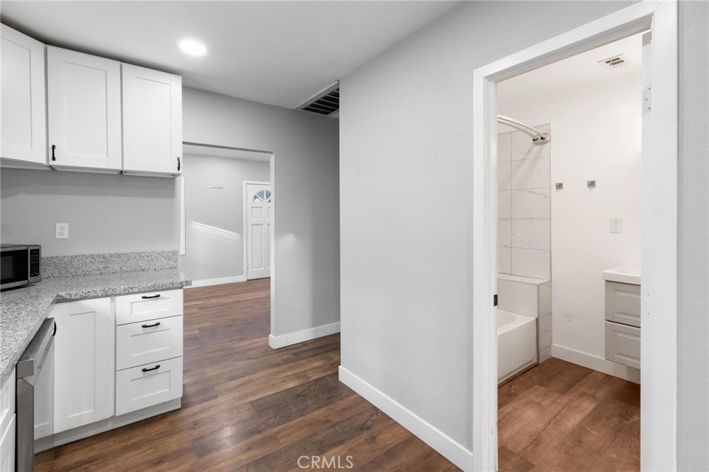 34789 Wildwood Canyon Road Yucaipa, CA 92399 - Photo 19 of 52 a kitchen with white cabinets and wooden floor