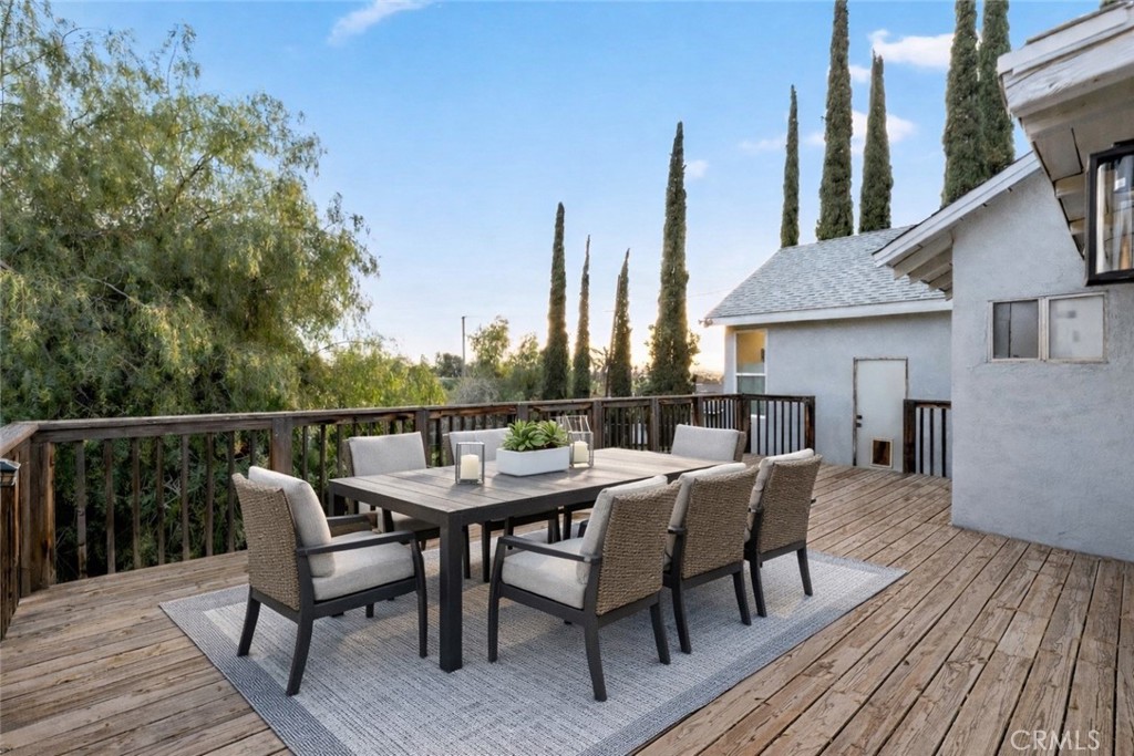 34789 Wildwood Canyon Road Yucaipa, CA 92399 - Photo 36 of 52 a view of a roof deck with table and chairs a barbeque with wooden floor and fence