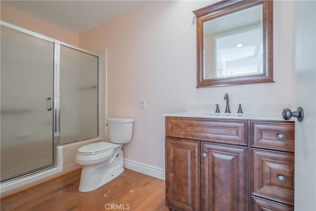 2103 Ronda Granada, Unit B Laguna Woods, CA 92637 - Photo 19 of 22 a bathroom with a granite countertop toilet sink and mirror