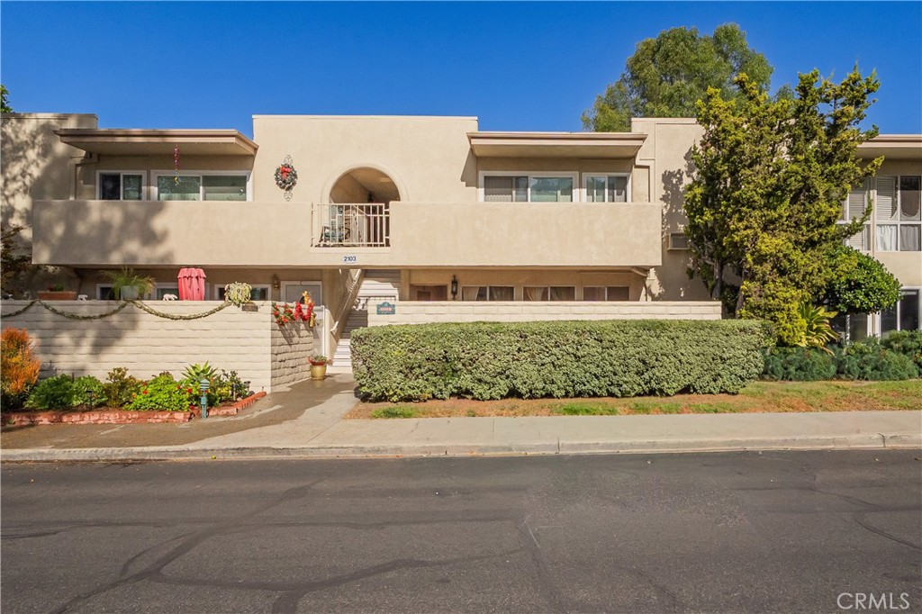 2103 Ronda Granada, Unit B Laguna Woods, CA 92637 - Photo 6 of 22 a front view of a house with a yard