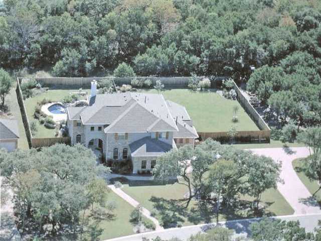 an aerial view of a house with a yard basket ball court and outdoor seating