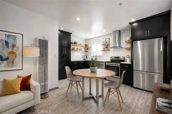 a kitchen with stainless steel appliances refrigerator dining table and chairs