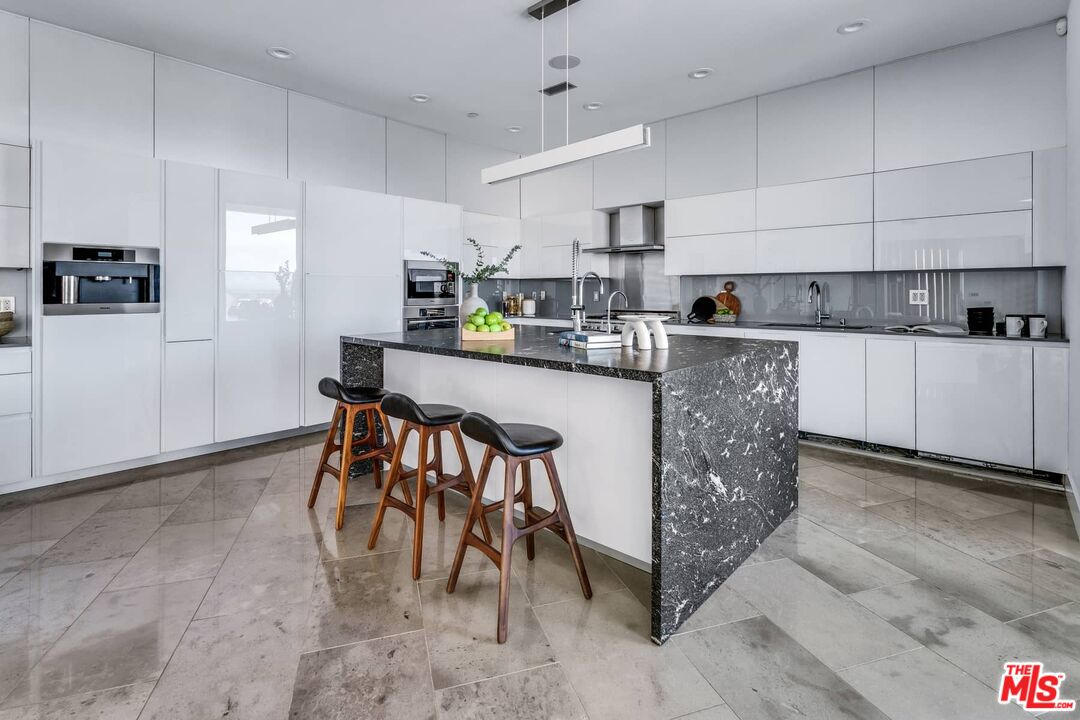 4634 Libbit Avenue Encino, CA 91436 - Photo 16 of 40 a kitchen with stainless steel appliances granite countertop a table chairs sink and cabinets
