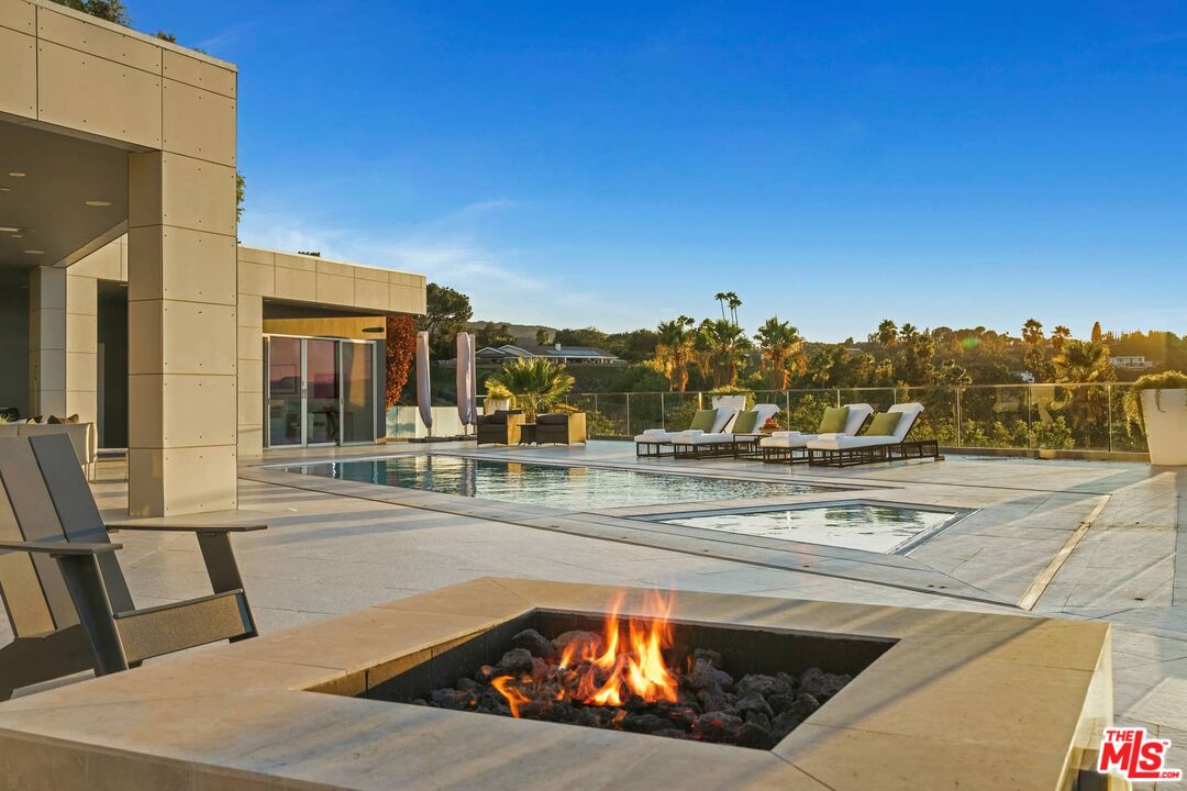 4634 Libbit Avenue Encino, CA 91436 - Photo 35 of 40 a view of a swimming pool with a lawn chairs and floor to ceiling window
