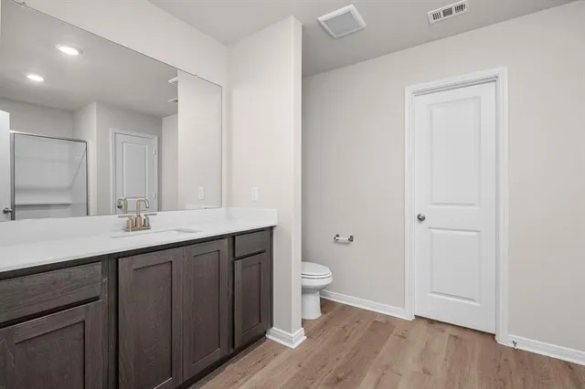 a bathroom with a granite countertop sink toilet and mirror