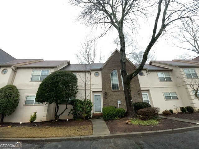 304 Bridge Lane Smyrna, GA 30082 - Photo 5 of 6 a view of a white house next to a yard with potted plants