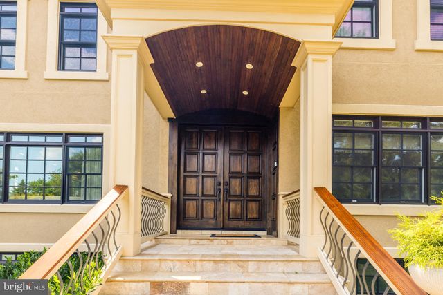 a front view of a house with swimming pool and sitting area
