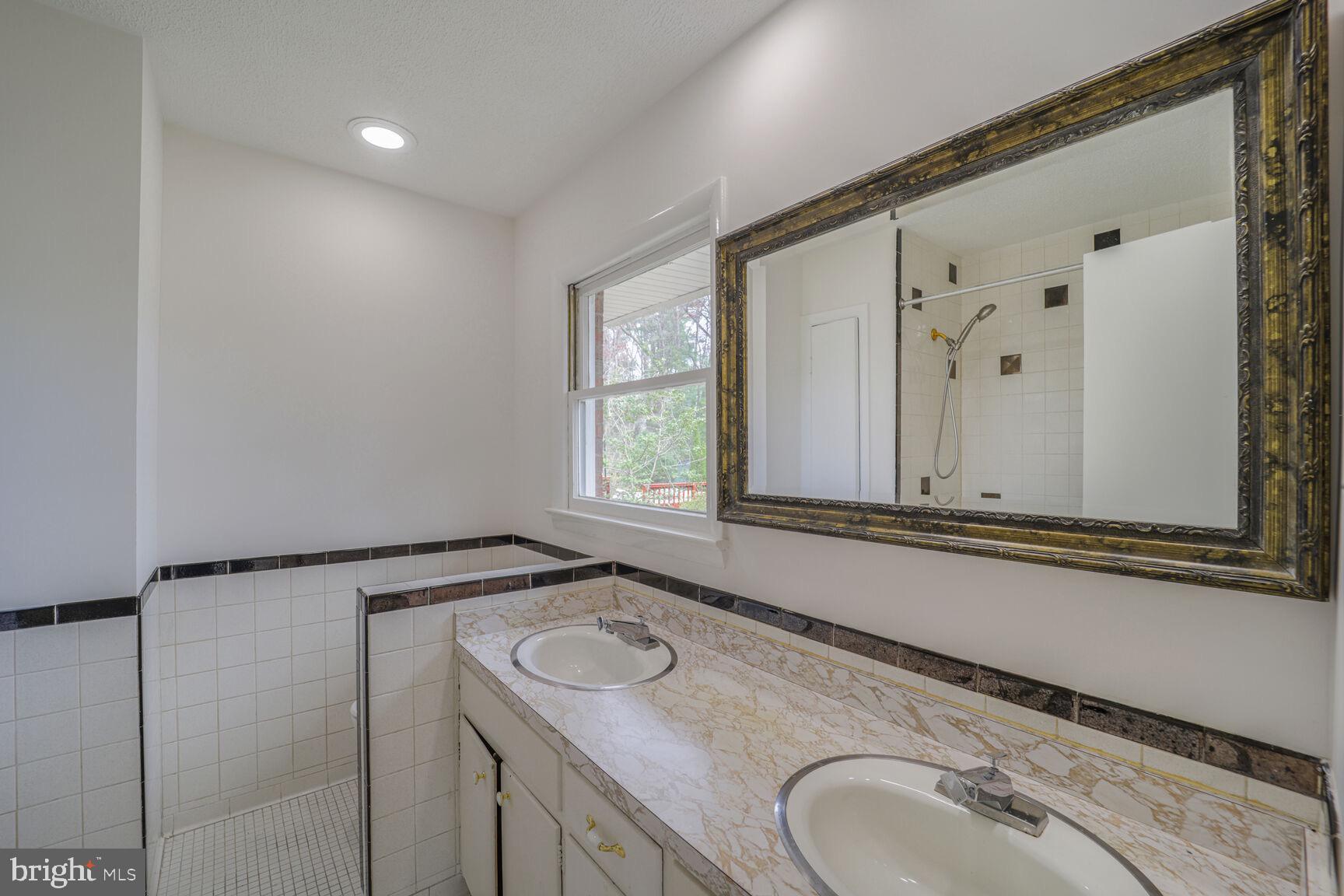5017 Ravensworth Road Annandale, VA 22003 - Photo 18 of 40 a bathroom with a sink and a mirror