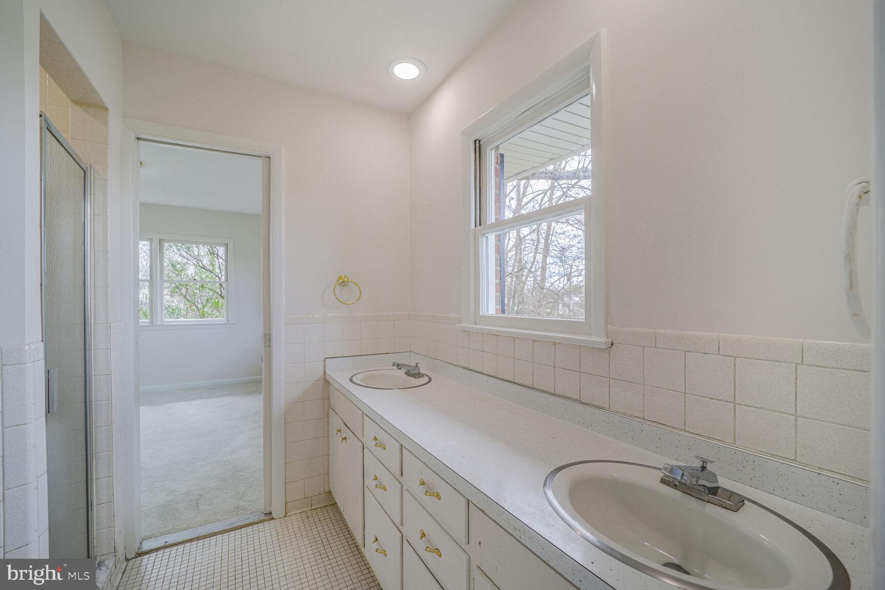 5017 Ravensworth Road Annandale, VA 22003 - Photo 24 of 40 a bathroom with a sink a mirror and a window