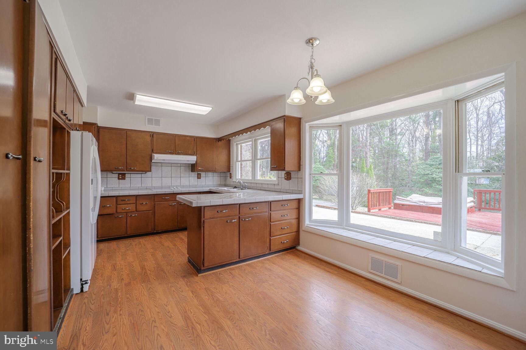 5017 Ravensworth Road Annandale, VA 22003 - Photo 8 of 40 a kitchen with stainless steel appliances granite countertop a refrigerator a sink dishwasher a oven with wooden cabinets and floor
