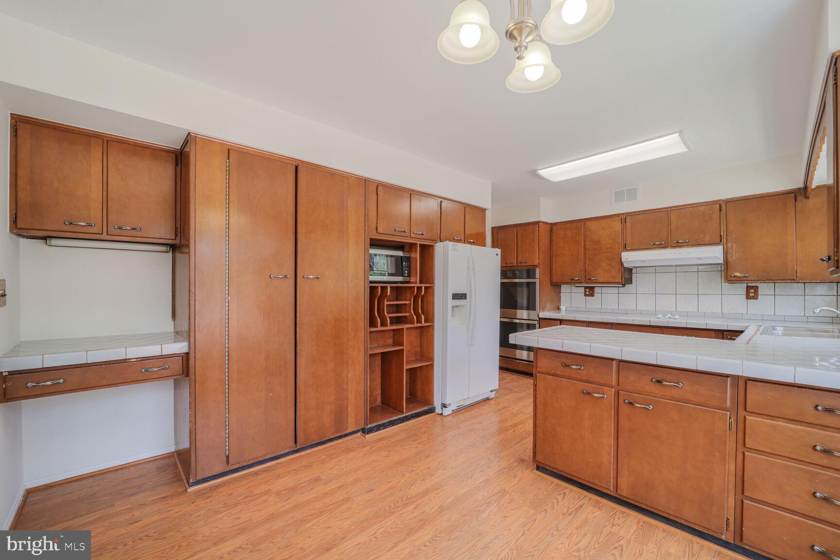 5017 Ravensworth Road Annandale, VA 22003 - Photo 9 of 40 a kitchen with stainless steel appliances granite countertop a refrigerator and cabinets