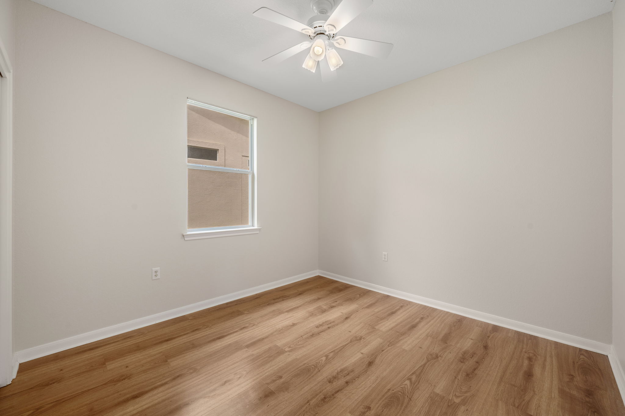 118 Bass Street Georgetown, TX 78633 - Photo 27 of 40 A well-lit bedroom with modern wood-look flooring and a functional ceiling fan, awaiting your personal touch.