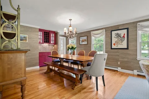 a view of a dining room with furniture a chandelier and wooden floor