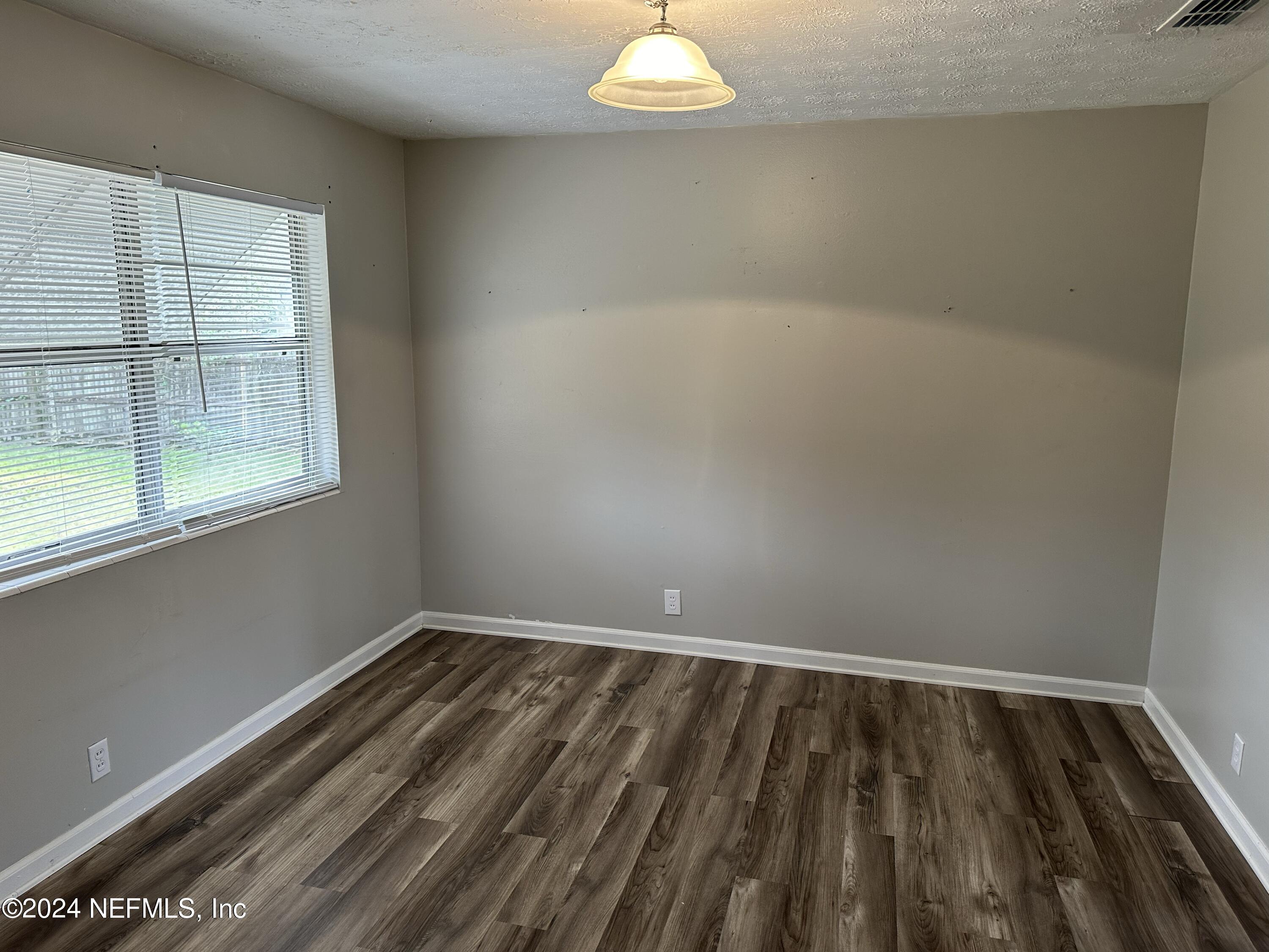 7417 Coral Sea Road Jacksonville, FL 32244 - Photo 4 of 10 a view of a room with wooden floor and windows