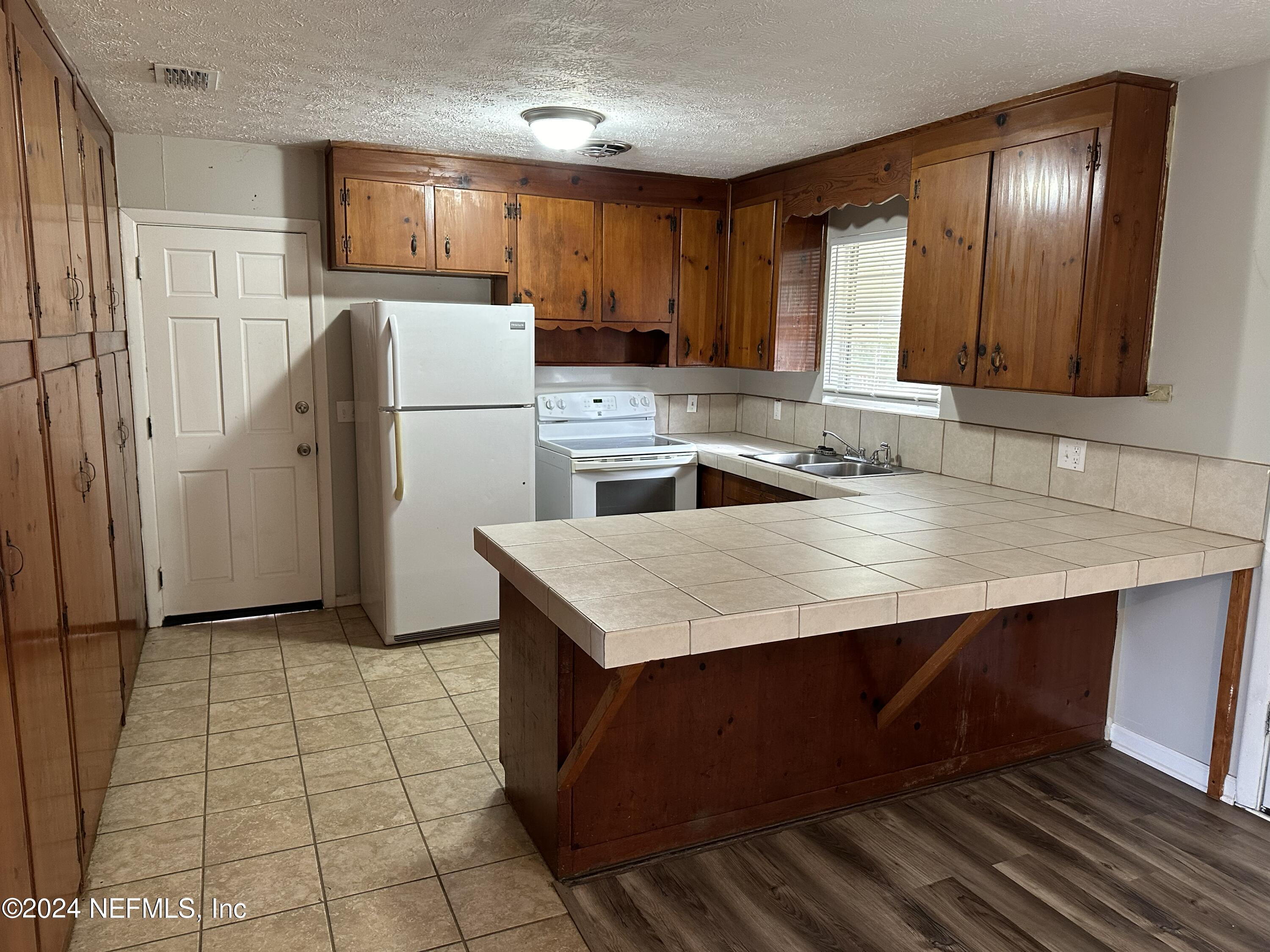 7417 Coral Sea Road Jacksonville, FL 32244 - Photo 5 of 10 a kitchen with a sink a refrigerator and cabinets