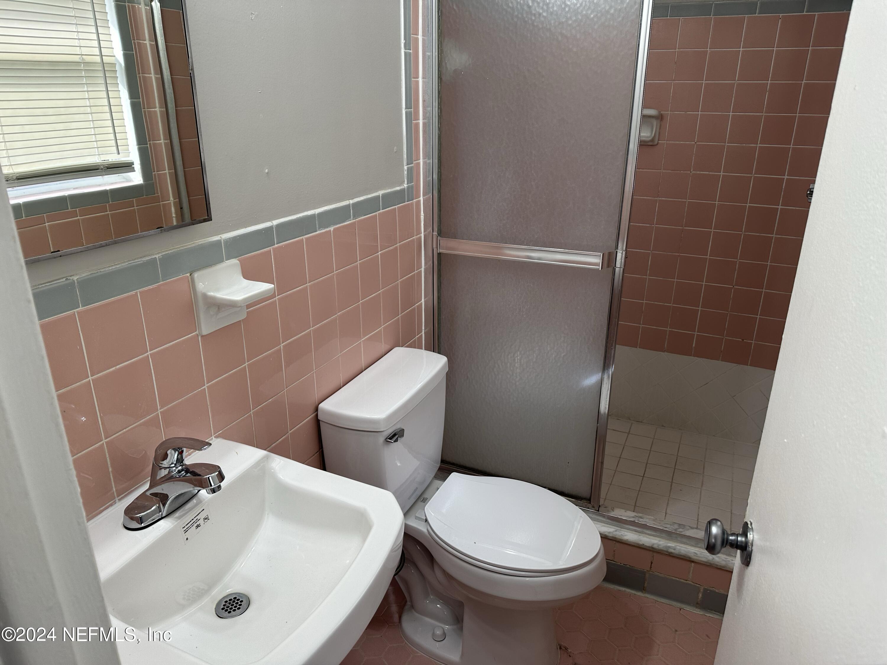 7417 Coral Sea Road Jacksonville, FL 32244 - Photo 7 of 10 a bathroom with a sink a toilet and a mirror