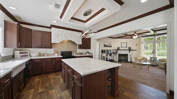 a living room with furniture floor to ceiling window and wooden floor