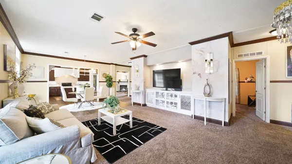 a living room with furniture a flat screen tv and a chandelier