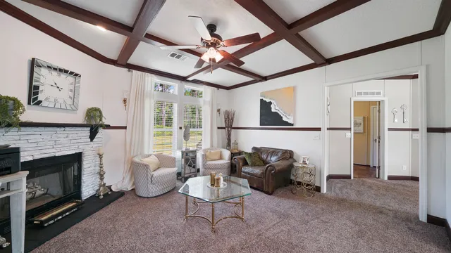 a living room with furniture a ceiling fan and a fireplace