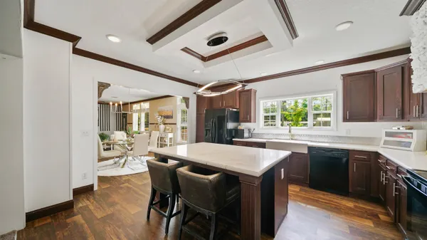 a kitchen with stainless steel appliances granite countertop a stove a sink dishwasher and a refrigerator with wooden floor