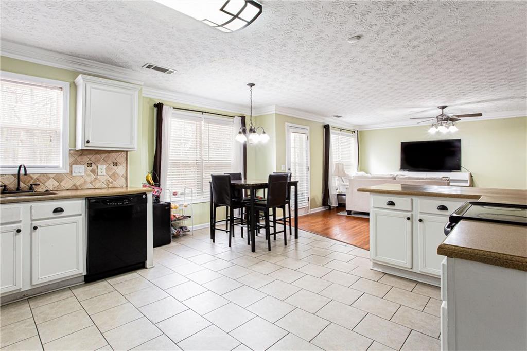 20 Trelawney Run Covington, GA 30016 - Photo 14 of 26 a kitchen with stainless steel appliances kitchen island granite countertop a stove top oven a sink dishwasher and a refrigerator