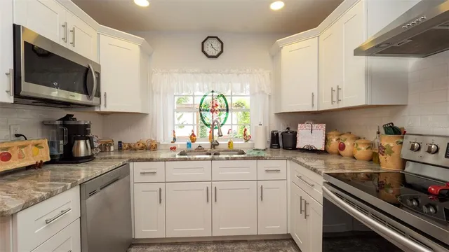a kitchen with granite countertop cabinets stainless steel appliances and a sink