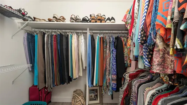 a view of walk in closet with clothes and shoes